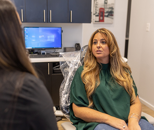Woman in the dental chair talking to her dentist