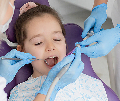 Young girl in the dental chair receiving a treatment