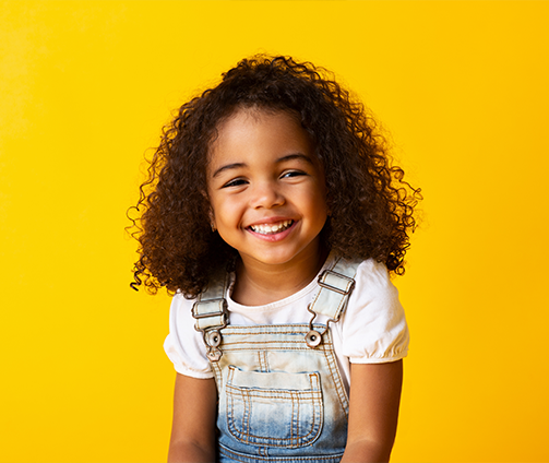 Smiling young girl in overalls