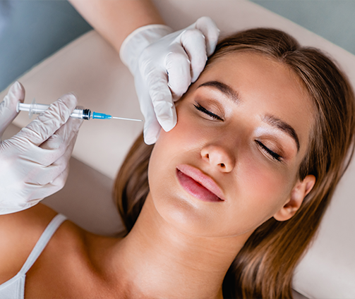 Young woman receiving an injection near her cheekbone