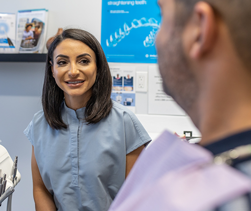 Dentist talking to a patient in the treatment chair