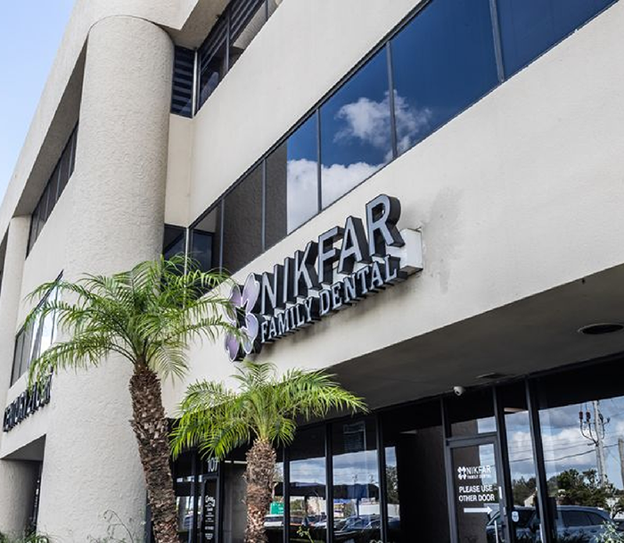 Two palm trees in front of Nikfar Family Dental office in Orlando