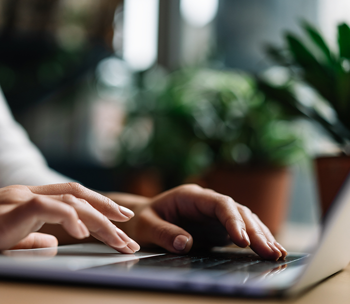 Close up of hands typing on a laptop