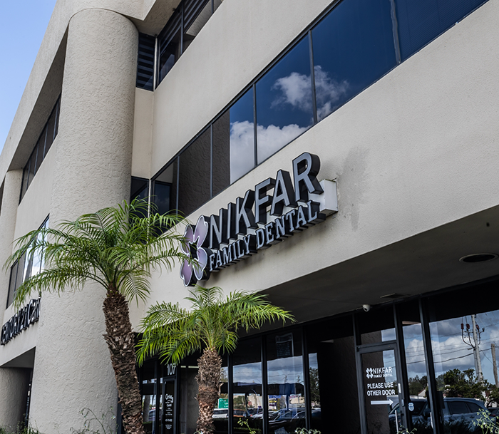 Two palm trees in front of Nikfar Family Dental office in Orlando