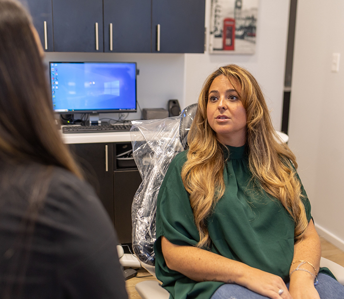 Woman in the dental chair listening to her dentist