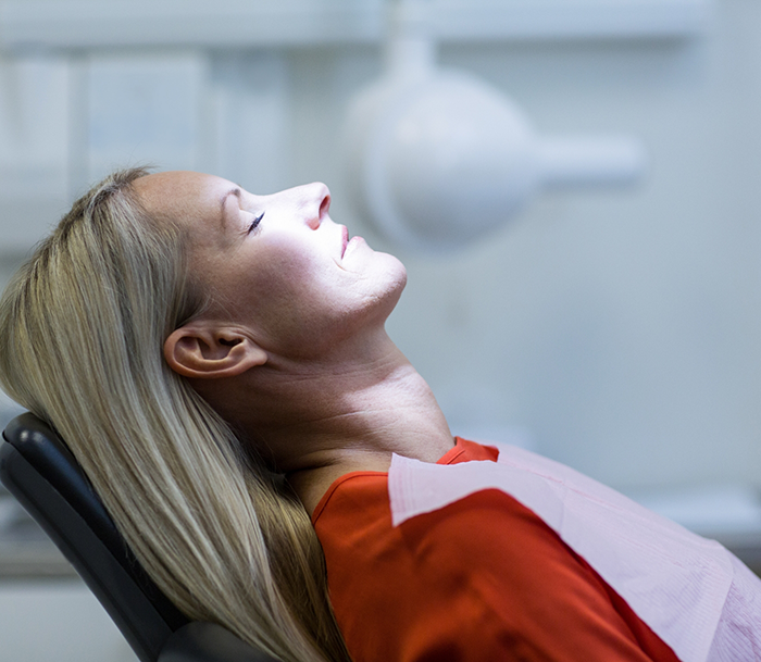 Woman relaxing in the dental chair thanks to sedation dentistry in Orlando